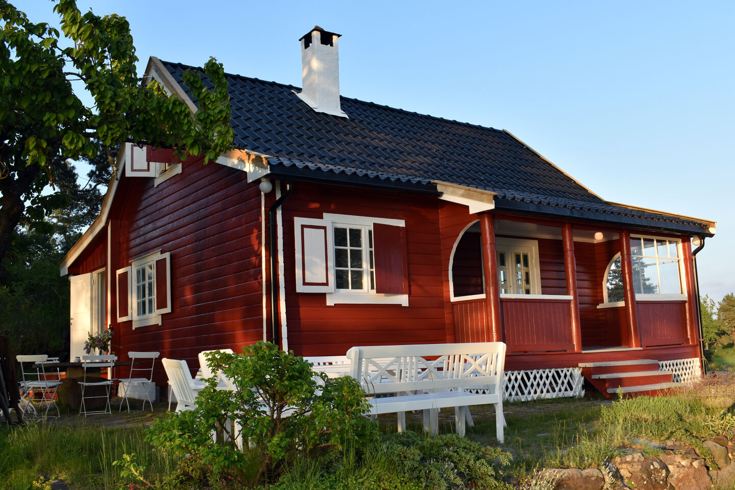 Rødt nymalt hus foran blå himmel